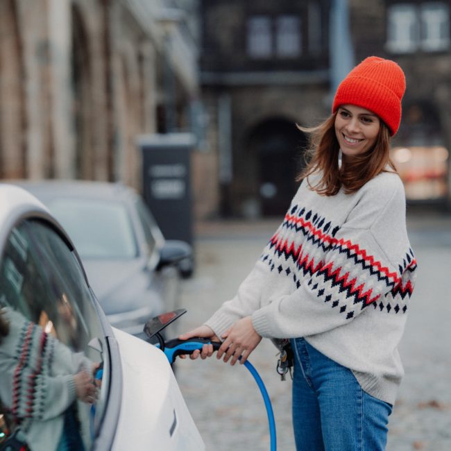 Woman plugging in her electric vehicle