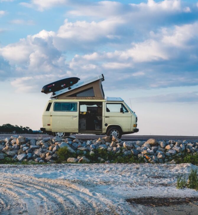 A camper van parked up on a pebble beach