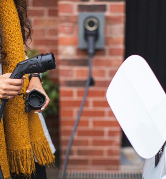 Person plugging a charger in to their EV